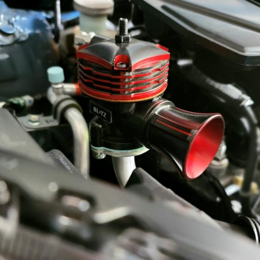 The red and black Blitz Blow-Off Valve installed in the engine of a Turbo Suzuki Every