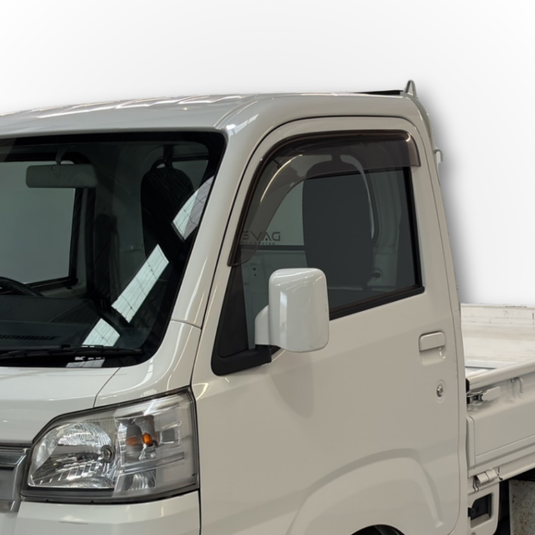 Close-up of the black Daihatsu Hijet Weather Shields installed on a white Hijet