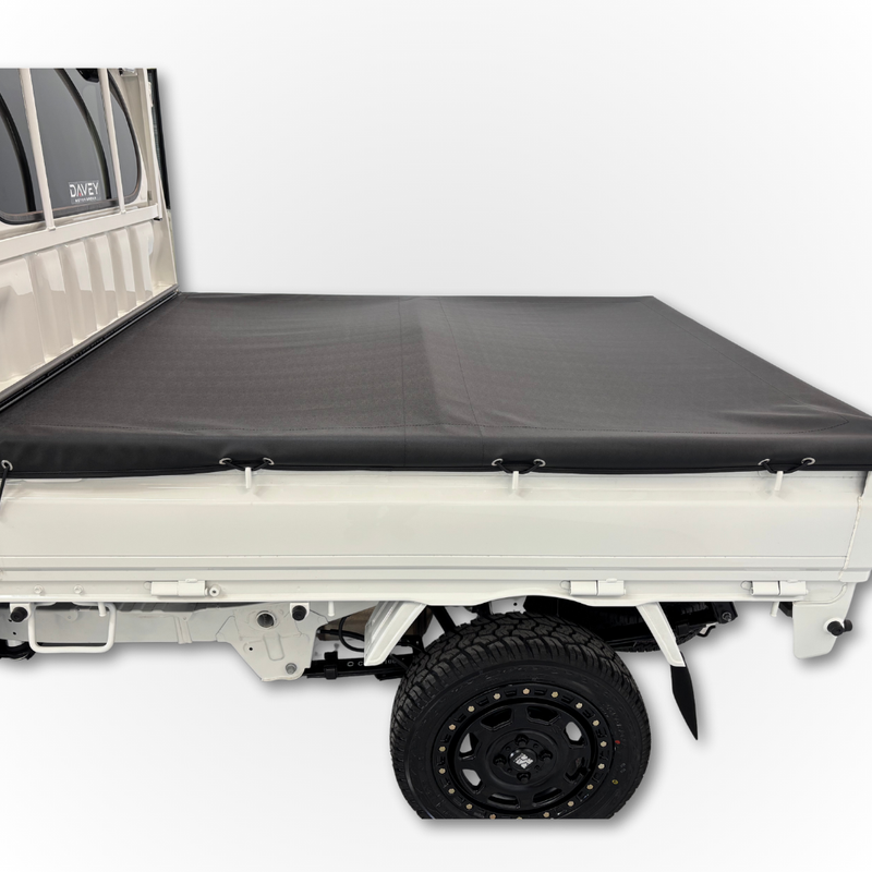 Load image into Gallery viewer, The Davey Motor Group Daihatsu Hijet Jumbo Tonneau Cover installed on a white Daihatsu Hijet Jumbo shown from the side
