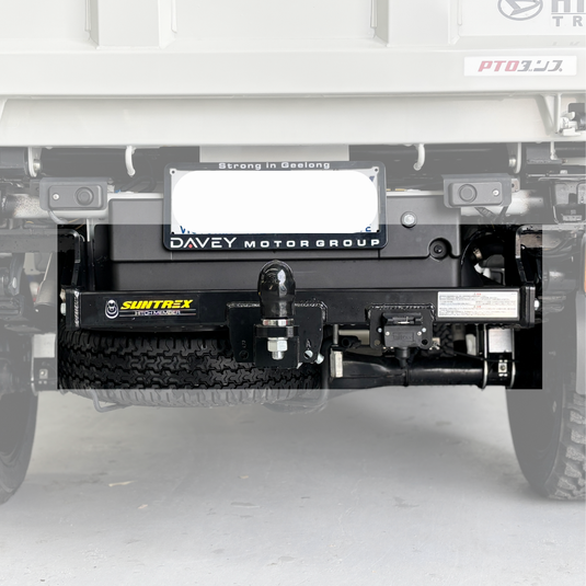 An installed Towbar sitting on the back of a cream Daihatsu Hijet. Focusing on the Towbar (blurring out surroundings)